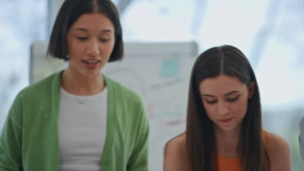 オフィスの同僚を聞く集中した女の子たち オフィス会議室で協力してスタートアップチームのブレインストーミング オフィスデスクの職場で多様なビジネス女性図面戦略計画 — ストック動画
