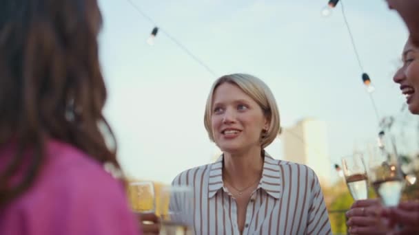 一个情绪化的女人在房顶的活动中讲述了一个故事 年轻的朋友们在屋顶聚会上享受彼此交流的时光 开开心心的女生在聚会上一起喝香槟酒 — 图库视频影像
