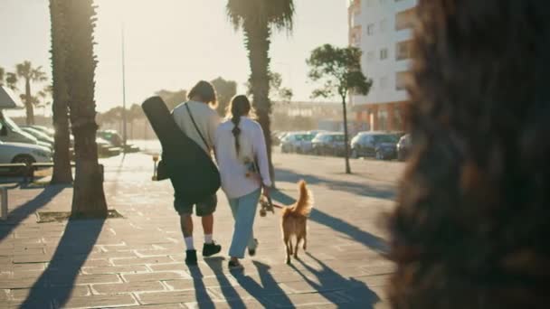 Két Fiatal Sétálgat Nyári Utcában Kisállat Visszapillantóval Ismeretlen Férfi Korcsolyázik — Stock videók