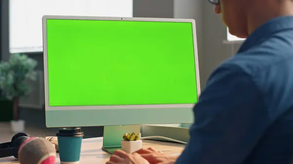 Businessman texting chromakey computer keyboard at office closeup. Unrecognizable man working green screen pc device writing email at table workplace. Unknown startuper pushing buttons staring monitor