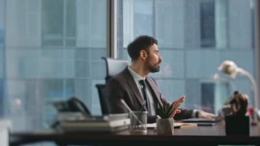 Ofis çalışanı, modern bir şirket olan dizüstü bilgisayarla zum toplantısı yapıyor. Kendine güvenen sakallı danışman iş yerindeki video konferansında müşteriyle konuşuyor. Kurumsal eğitimde başarılı konuşmacı.