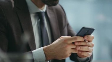 Akıllı girişimci cep telefonuyla şirket ofisini kapatıyor. Yakışıklı sakallı iş adamının portresi akıllı telefon ekranlı bir yazı. Cep telefonu kullanan kendinden emin ciddi bir yönetici