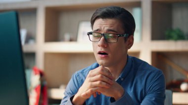 Gülümseyen serbest çalışan modern ofiste görüntülü sohbeti bitiriyor. Bilgisayar başında barış jesti gösteren bir girişimci. Yaratıcı iş adamı, olumlu bir ifadeyle sanal buluşmadan zevk alıyor.