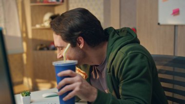 Gülen serbest çalışanlar pizza yiyorlar. Ofiste eğleniyorlar. Duygusal erkekler hazır yiyeceklerin tadını çıkarıyorlar. Birlikte takılıyorlar. Gülümseyen iş arkadaşları yemek yiyor. Öğle arasında iyi ilişkiler.