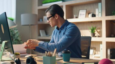 Modern ofisteki defterleri karıştıran ilham verici bir adam. Kapalı gözlüklü, serbest çalışan, projeye hazırlanan, yeni bir fikri olan biri. Esmer işadamı bilgisayar ekranına bakıyor ve yalnız çalışıyor.