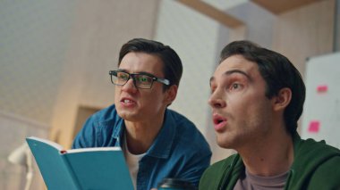 Ofiste bilgisayar ekranına bakan duygusal partnerler. Gözlüklü yaratıcı iş adamı meslektaşına notlar yazıyor. İki gülümseyen yaratıcı mutlu bir şekilde kamera görüntüsünü hareket ettiriyor.