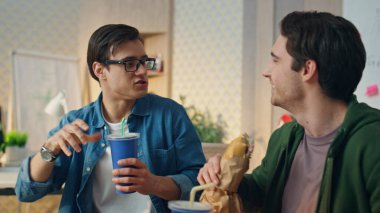 Mutlu meslektaşlar öğle yemeği yerken yakından monitör izliyorlar. Duygusal bağımsızlar projeyi tartışırken el kol hareketi yapıyorlar. Aktif takım arkadaşları yemek molasında sağlıklı yemek yiyor.