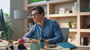 Ofisin iç kısmında bilgisayar klavyesini daktilo eden odaklı yaratıcı. Ciddi bir web tasarımcısı bilgisayar monitöründe çalışıyor. Gözlüklü adam klavye tuşlarına basıyor ve dolapta tek başına çalışıyor.