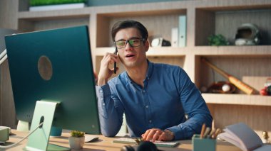 Ofiste akıllı telefon konuşmanı kutlarım. Modern iç mekânda cep telefonu seçerek başarılı bir serbest çalışan bitirme araması. Gözlüklü adam boş dolapta bilgisayar ekranı izliyor. 