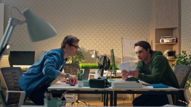 İş yerinde birlikte danışmanlık yapan ciddi ortaklar. Gözlüklü adam açık ofis masasında rengini seçen erkek arkadaşla konuşuyor. Uzaktan çalışan yaratıcı serbest çalışanlar. Çalışma rutini kavramı