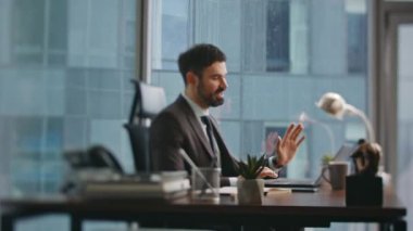 İş adamı ofis masasında dizüstü bilgisayar arayan bir ekiple sanal toplantı yapıyor. Sakallı mutlu menajer video görüşmesinde konuşuyor. Profesyonel pazarlamacı Zoom Sohbeti 'nde online danışmanlık yapıyor. Uzak iletişim.