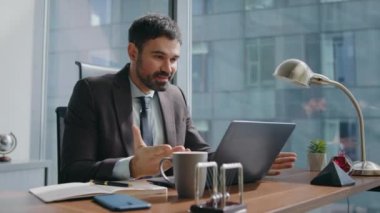 Modern ofisteki çevrimiçi konferansta hevesli bir işçi konuşuyor. Mutlu iş adamının iş yerinde keyifli bir video görüşmesi var. Gülümseyen sakallı girişimci internet haberleşmesini kutluyor..