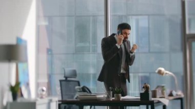 Kızgın girişimci, lüks ofiste stres hissederek akıllı telefon fırlatmayı hayal kırıklığına uğrattı. Sinirli sakallı iş adamı iş masasına yaslanmış telefon konuşmasını bitir. Duygusal patron başarısızlıktan bitap düştü.