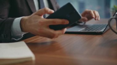 Çalışan eller dizüstü bilgisayarda yazarken modern akıllı telefonları yakına çekiyor. Modern işyerindeki telefon görüşmelerine yakışıklı sakallı iş adamı cevap veriyor. Gülümseyen mutlu ofis müdürü arkadaşça telefon konuşmalarının keyfini çıkar.
