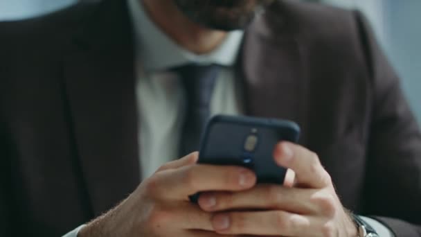 近代的なスマートフォンの座っているオフィスのSmsを入力するハンサムなボス 職場で電話を使って業務を解決する真剣な自信を持ったマネージャーの肖像画 ひげ付きビジネスマンメッセージ — ストック動画
