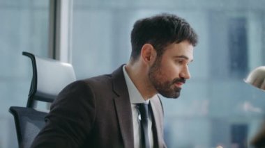 Şirket ofisindeki video konferansında konuşan yakışıklı konuşmacının portresi. Kendine güvenen güler yüzlü iş adamı koçu lüks bir şirkette webinar yönetiyor. Mutlu adam yönetici video kapatılıyor.