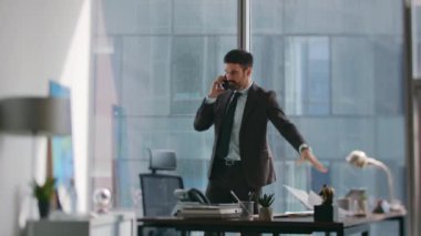 Modern şirket iş yerindeki hayal kırıklığına uğramış CEO konuşan cep telefonu tatminsiz iş raporu. Sinirli yöneticinin gergin telefon konuşması lüks bir ofiste yapılıyor. Kızgın patron içeri çağırıyor..