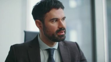Hüsrana uğramış patron, şirketin ofisinde otururken yaptığı hataya kızıyor. Öfkeli sakallı iş adamı, kapalı alandaki iş krizine duygusal tepki veriyor. Stresli yatırımcı kar kaybı konusunda endişeli