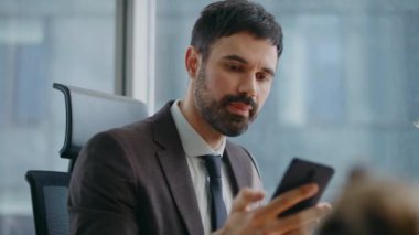 Modern işyerindeki meşgul iş adamlarından biri çağrıya cevap veriyor. Ciddi yönetici ofis masasında oturmaktan memnun değil. Ciddi sakallı çalışan cep telefonuyla sorunu tartışıyor