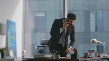 Modern ofiste şık bir takım elbiseyle akıllı telefondan konuşmakla meşgul. Başarılı bir iş adamı müşterilerini arayıp iş görüşmesi yapıyor. Akıllı yönetici uzaktan telefon çözme sorunları hakkında konuşuyor