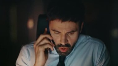 Endişeli yönetici, gece geç saatlerde telefon görüşmesinde tartışıyor. Kapatın. Sinirli iş adamı iş yerindeki telefon konuşmasını bitirdi. Stresli CEO iletişimden memnun değil.