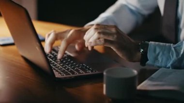 Yazar elleri bilgisayarda klavye yazarken gece geç saatlerde kapat. Odaklanmış sakallı şirket yöneticisi not defterindeki bilgileri kontrol etmek için rapor yazıyor. İşadamı geceleri bilgisayarla uğraşıyor..