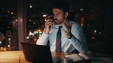 Stresli iş adamı akıllı telefon oturma masasına bağırıyor. Sinirli menajer iş sorununa duygusal tepki veren telefon görüşmesini bitirdi. Hüsrana uğramış CEO umutsuzluk içinde..