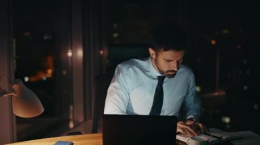 Çok çalışan şirket çalışanı gece geç saatlere kadar ofiste tek başına çalışıyor. Masa başında oturmuş sorun çözmekle meşgul sakallı adam. Yorgun işadamı fazla mesai yüzünden stresli.. 