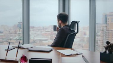 Zengin yönetim kurulu başkanı rahat ofis koltuğunda oturup kahve içiyor. Şehir manzarasına bakıyor. Kendine güvenen sakallı iş adamı işten çıkıyor. Sakin ol patron. Lüks dolapta çay fincanıyla dinleniyorsun..