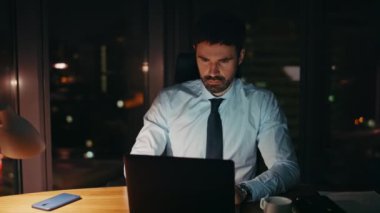 Kafası karışmış girişimci görünümlü dizüstü bilgisayar monitörü ofis masasında gece geç saatlerde kapatılıyor. Şirketin sorunlarından endişelenen çok çalışan bir iş adamı. Şirket yöneticisi karanlık işyerinde yazı yazıyor.