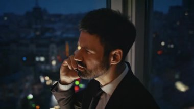 Çok çalışan bir iş adamı gece yarısı ofisin penceresinden arıyor. Ciddi bir yönetici, ortaklarıyla telefonda konuşuyor ve geceleri iş görüşmelerini bitiriyor. Sakallı işadamı telefonla konuşuyor..