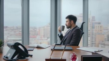 Kendine güvenen patron kahve molası veriyor lüks bir ofiste oturup pencereye yakından bakıyor. Düşünceli sakallı yönetici iş yerinde içki içerek iş kariyerini düşünüyor. Başarılı CEO içeride rahatlıyor.