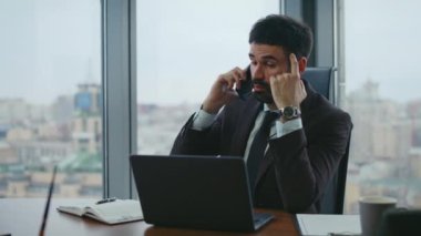 Ofis masasında oturan bir müşteriye danışmanlık yapıyorum. Akıllı bir iş danışmanı telefonda not defterine not alıyor. Ciddi bir çalışan iş arkadaşlarını arıyor..