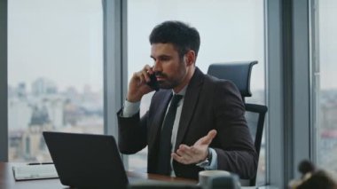 CEO telefonda tartışıyor. Lüks ofiste oturuyor. Umutsuzluğa kapılmış hissediyorum. Sakallı kızgın iş adamı konuşan telefonda kötü haberlere duygusal tepki veriyor. Sinir bozucu yönetici akıllı telefonda bağırıyor.