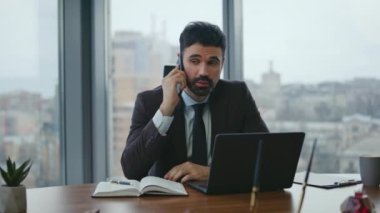 Akıllı yönetmen cep telefonu masasında dizüstü bilgisayarla konuşuyor. Kendine güvenen bir işadamı telefonda defterdeki notlara bakıyor. Sakallı adam yönetici, iş görüşmesi yapıyor..
