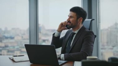 Mutlu yönetici konuşuyor. Akıllı telefon. Lüks ofis kapanıyor. Yakışıklı sakallı iş adamı telefonda keyifli sohbetler yapar. Neşeli şirket çalışanı. İş yerinde gülerek konuşan telefon..