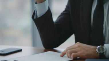 Modern ofis masasında oturan düşünceli yönetici kontratı imzalıyor. Ciddi bir yatırımcı imzalı iş anlaşmasını onaylıyor. Düşünceli adam, resmi anlaşmayı sonuçlandırıyor..