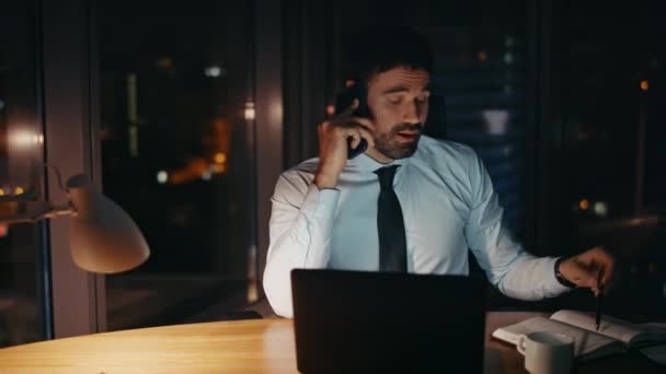 Overvældende Medarbejder Taler Smartphone Gør Noter Ved Skrivebordet Sent Aftenen – Stock-video