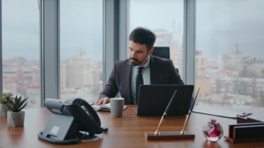 Çalışma masasındaki notlara bakarak dizüstü bilgisayar yazan bir iş adamı. Yakışıklı sakallı adam internet işinden sonra kahve içiyor lüks ofis şirketinde oturuyor. Başarılı girişimci ara veriyor..