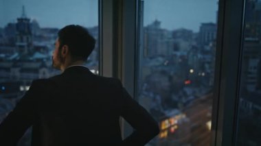 Dalgın yönetici ofis panoramik penceresinde gece şehir manzarasına bakıyor. Ciddi sakallı iş adamı gece yarısı şehir manzarasını tek başına izliyor. Ticaretten endişe duyan zarif bir işçi.