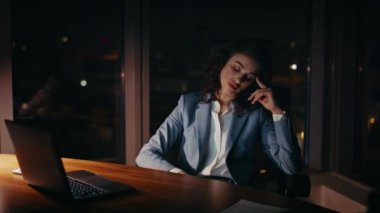 Depresyonda olan şirket çalışanı geceleri ofis masasında oturuyor. Uykusuz iş kadını karanlık işyerinde fazla mesai yapmaktan yoruldu. Hüsrana uğramış kız yönetici dizüstü bilgisayar görüntüsü.