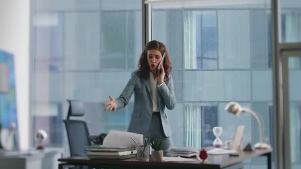 不高兴的经理站在写字台上感情用事地讲电话 焦虑的女人在电话中抱怨 担心利润损失 女导演在智能手机里吵架感觉到压力 — 图库视频影像