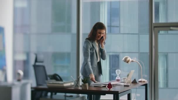 사무실 인테리어에서 비즈니스 보고서를 말하는 만족스러운 사업가 성공을 느끼는 전화에 — 비디오