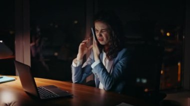 Yorgun bir iş kadını ofis bilgisayarında çalışırken telefon ediyor. Kapatın. Yorgun kadın yönetici gece iş yerinde son teslim tarihinden dolayı bunalmış. Akıllı telefondan konuşan üzgün bir kadın..