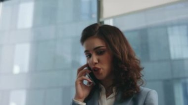 İş yerindeki başarısızlıkla ilgili akıllı telefonlardan bahseden deli bir kadın. Ofis panoramik penceresinde telefonla işçilere bağıran öfkeli iş kadını. Kızgın kadın hayal kırıklığı sorunu