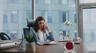 Sinirli iş kadını ofisteki laptopu arıyor. Kapatın. Sinirli kız yönetici telefonda tatminsiz şirket işlerini tartışıyor. Genç bayan patron hayal kırıklığını ifade ediyor..