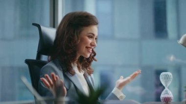 Heyecanlı iş kadını web kamerası bilgisayarından konuşuyor iş başarısını ofiste yakından paylaşıyor. Mutlu güzel bayan patron video toplantısında duygusal konuşuyor. Gülümseyen kız menajerin video konferansı var.