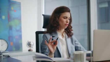 Çalışan video pazarlığında konuşuyor. Lüks ofis kapanışı. Kendine güvenen başarılı bir iş kadını uzak bir toplantıda iş projesini tartışıyor defterdeki notlara bakıyor. Bayan patron zoom yapıyor.