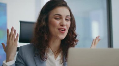 Ofis bilgisayarından duygusal çalışan videosu arıyor. Web kamerasına bakıp yakından gülümsüyor. Heyecanlı güzel bayan menajer çevrimiçi toplantıda el kol hareketi yapıyor. Başarılı iş kadını kendini mutlu hissediyor..