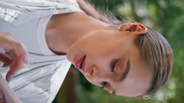 Rahat iş kadını cep telefonuyla mesajlaşıyor. Yaz parkına yakın duruyor. Kendine güveni tam güzel bir kadın. Akıllı telefondan neşeli bir şekilde mesaj atıyor. Dikey gülümseyen güzel sarışın kamera..